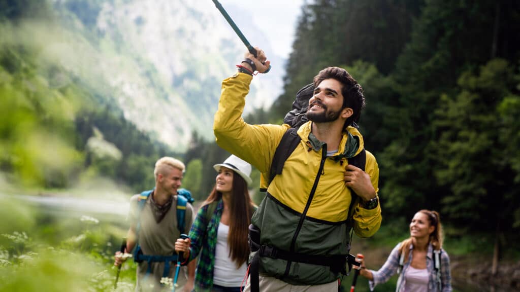 Group of smiling young people hiking in nature