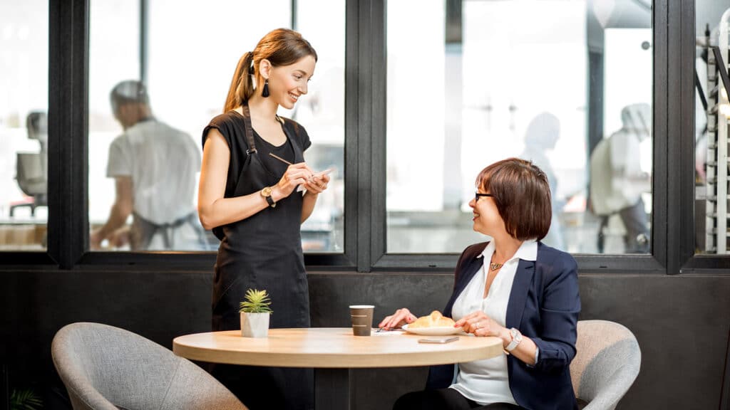 Waitress taking customer's order in a cafe